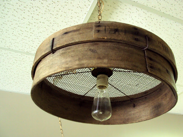 Old grain sieve repurposed into a primitive chandelier